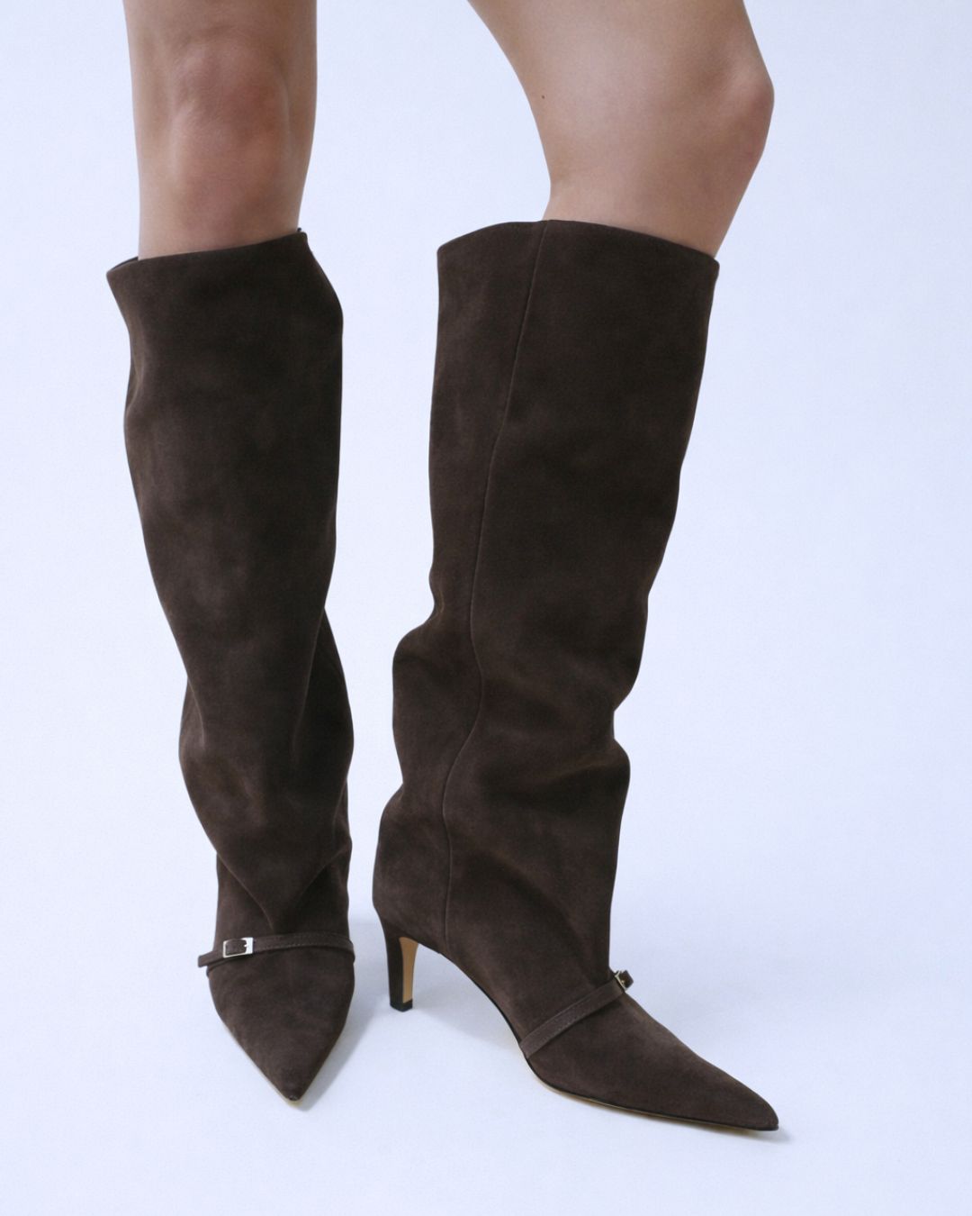 Brown knee-high boots with a strap on a white background