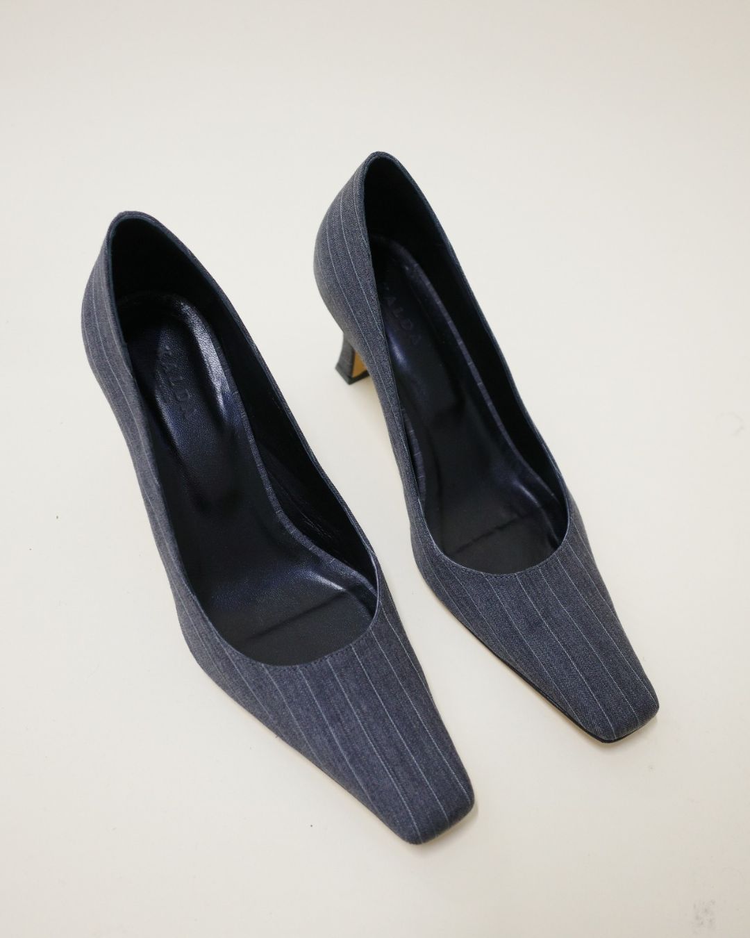 Pair of KALDA grey pinstripe shoes on a light background