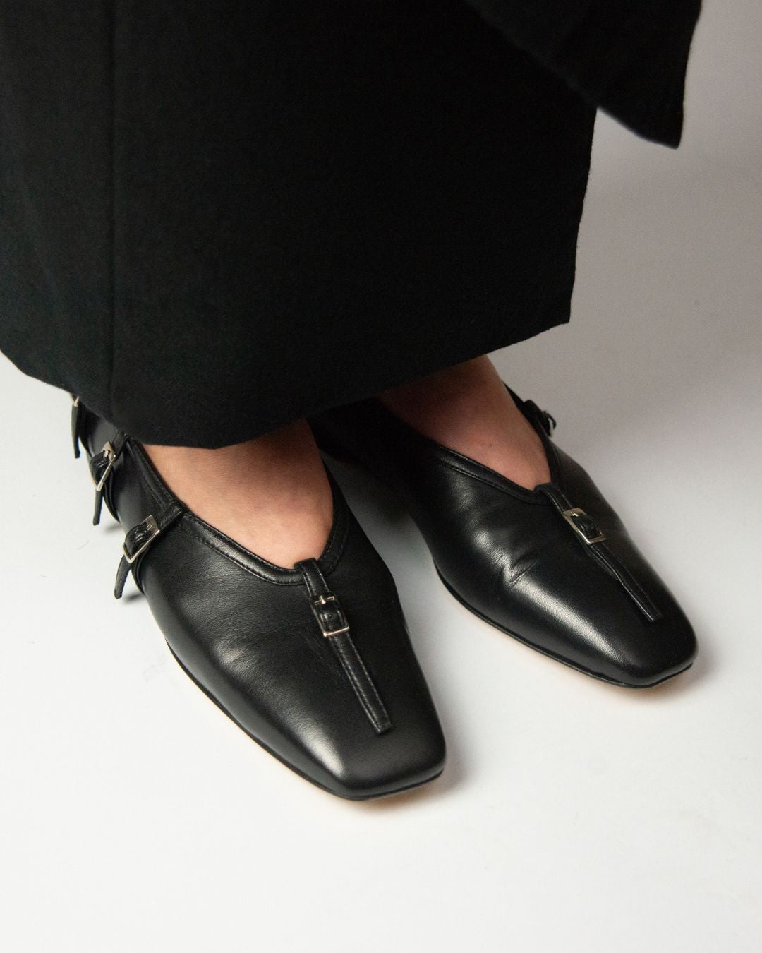 KALDA black leather flat shoes with buckle strap detail, on foot